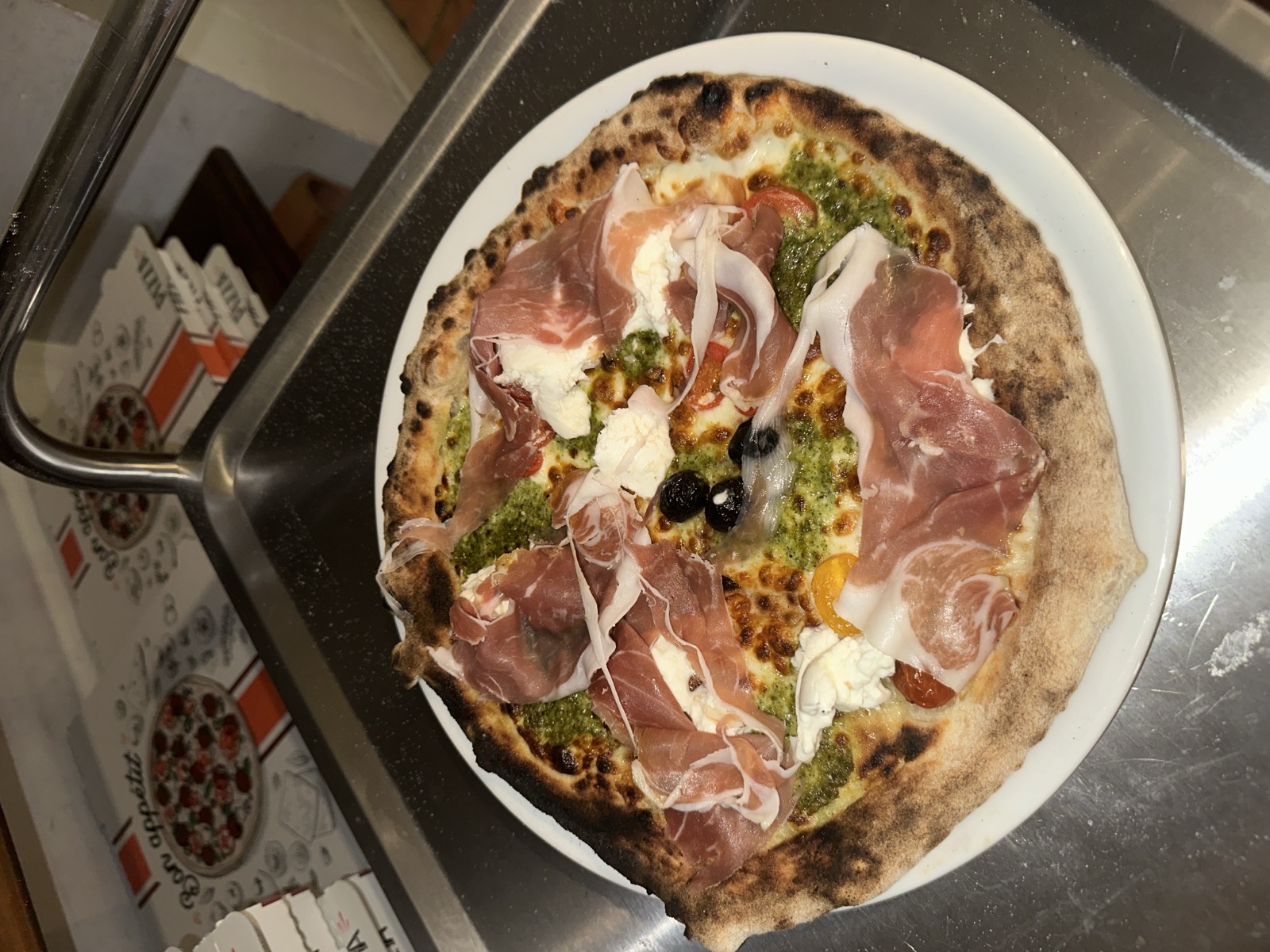 Pizza au prosciutto, pesto et burrata, cuite au feu de bois